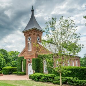 brown-concrete-building-near-green-trees-under-white-clouds