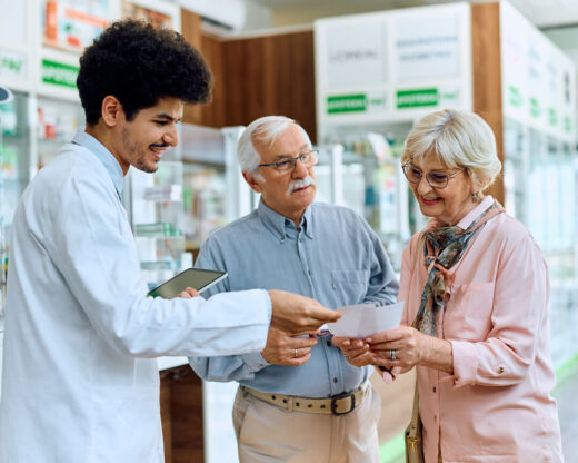 pharmacist assisting couple choose prescriptions