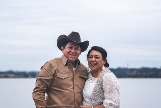 A smiling older couple in Texas standing outdoors by a lake, symbolizing choosing the best Medicare Advantage plans in Texas