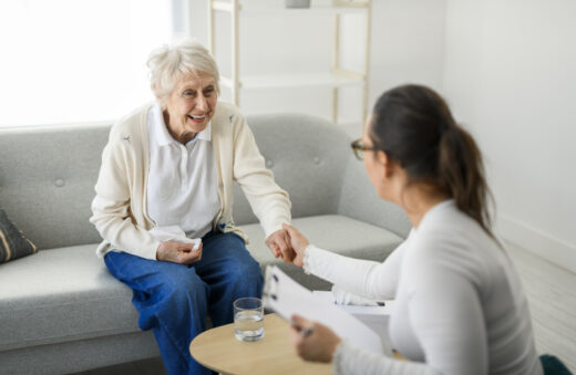 Caregiver assisting older parent with choosing the right Medicare plan, reviewing healthcare paperwork together in a home setting.
