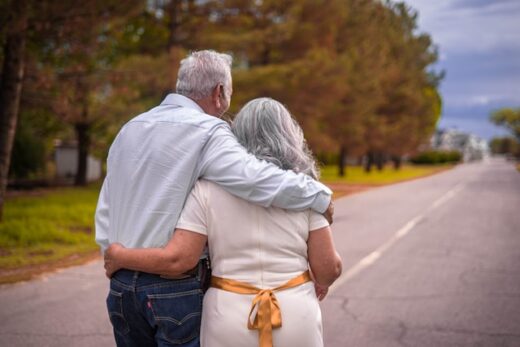 Senior couple walking together outdoors, symbolizing support and decision-making during Medicare enrollment.